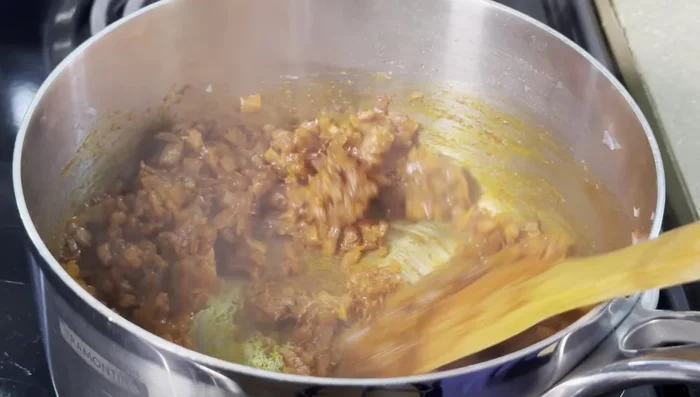 Crack eggs into the simmering sauce.
