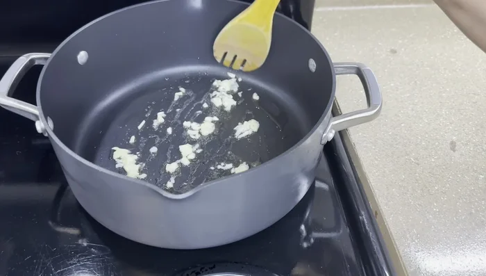 Sauté onions, garlic, and ginger in oil until softened. (This step is implied and not explicitly stated in the transcript)