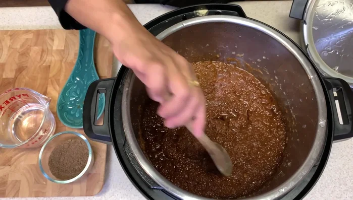After several hours of cooking (the author took breaks), add more berbere and butter for extra spice and flavor. This process may take several hours over multiple days.