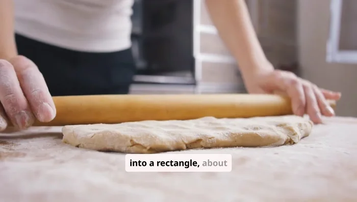 Roll the dough into a rectangle about 9 by 8 inches. Spread the softened butter over the dough. Then mix the cinnamon and sugar together and sprinkle it generously over the top.