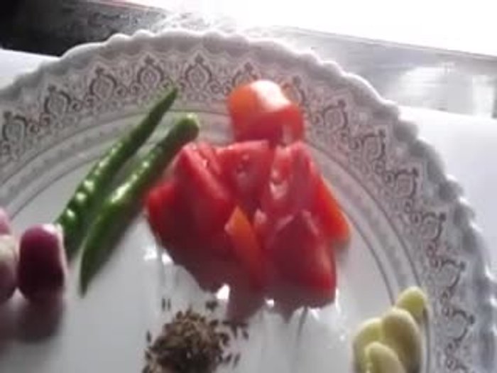 Grind shallots, tomatoes, garlic, curry leaves, cumin seeds, and green chilies together.
