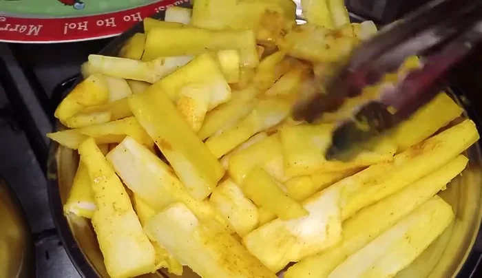Heat oil in a pan for deep frying. Once the oil is hot, carefully add the cassava slices and fry until golden brown and crispy.
