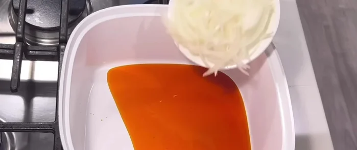 In the same pot, add palm oil, sliced onions, and fry for 5 minutes.