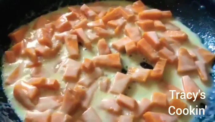 Start by stewing the pumpkin in coconut milk on high heat until it simmers.