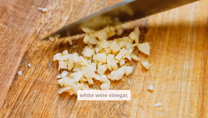 Whisk together olive oil, lime and lemon juices, white wine vinegar, minced garlic, cumin, salt, and pepper until emulsified.
