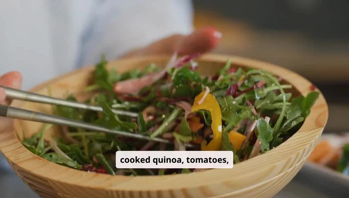 Combine cooked quinoa, tomatoes, cucumber, onion, bell pepper, arugula, and fresh herbs in a bowl. Drizzle with dressing and toss gently.